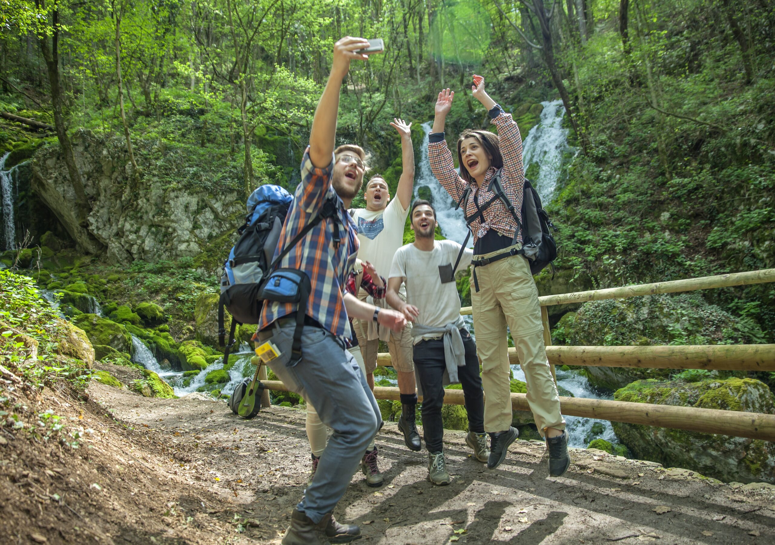 Group of friends having fun and taking selfies in nature